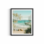 Lone surfer riding a wave at Wategos Beach framed by coastal trees — A Pocket of Paradise fine art print by Saxon Kent