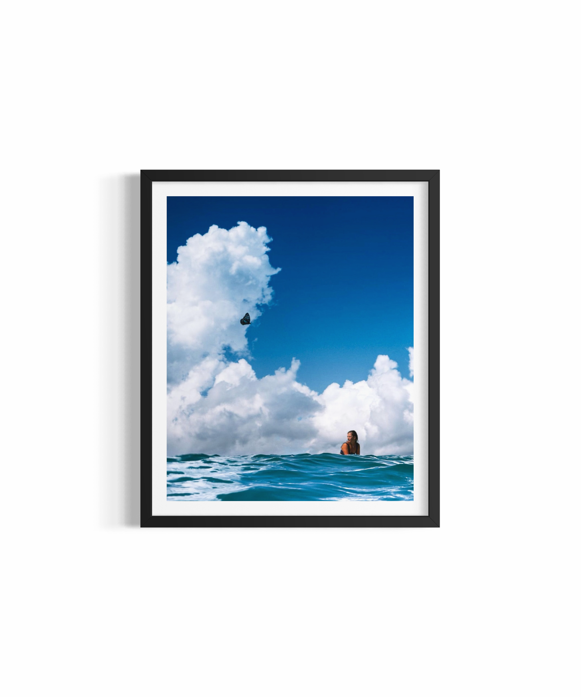 Dreamy figure floating in blue ocean beneath cumulus clouds at Wategos Beach — Attract fine art print by Saxon Kent
